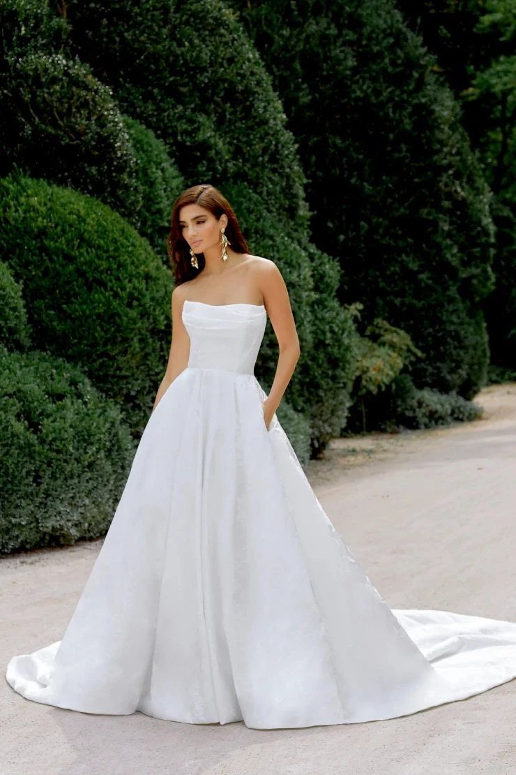 Model wearing white Justin Alexander dress